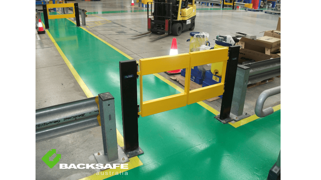 High-visibility barrier gate by Backsafe AU placed across a designated green pedestrian path in a warehouse to ensure safety near forklift zones.